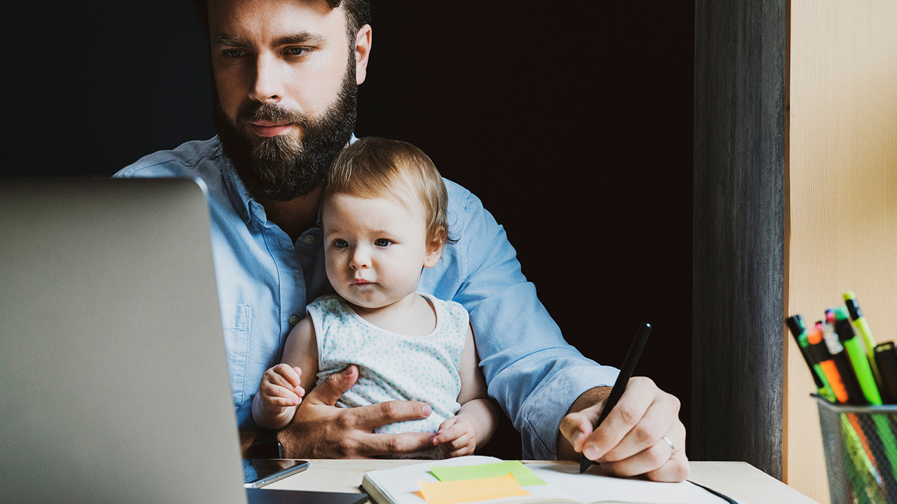 Adult student studying while holding child